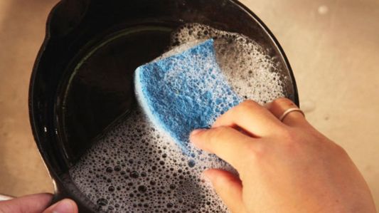 washing a cast-iron pan with soap